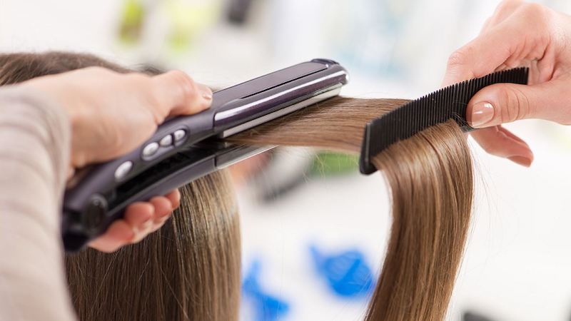 woman having hair straightened