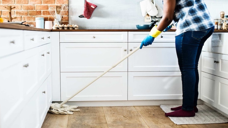 Person cleaning the kitchen floor with a mop