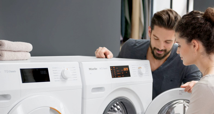 woman and man loading a washing machine