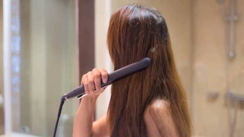 woman straightening hair