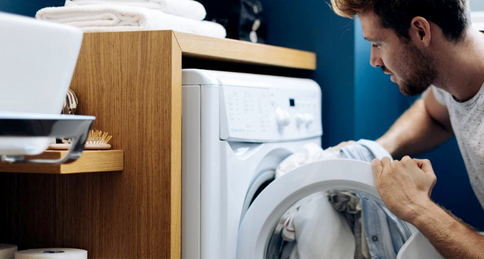 Man loading white washing machine