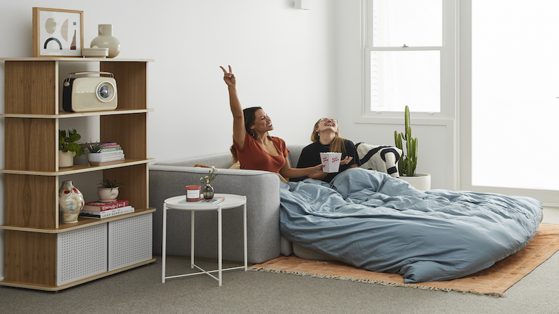 Two women sitting on a sofa bed