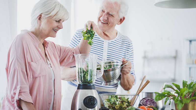 Man and woman filling electric food processor
