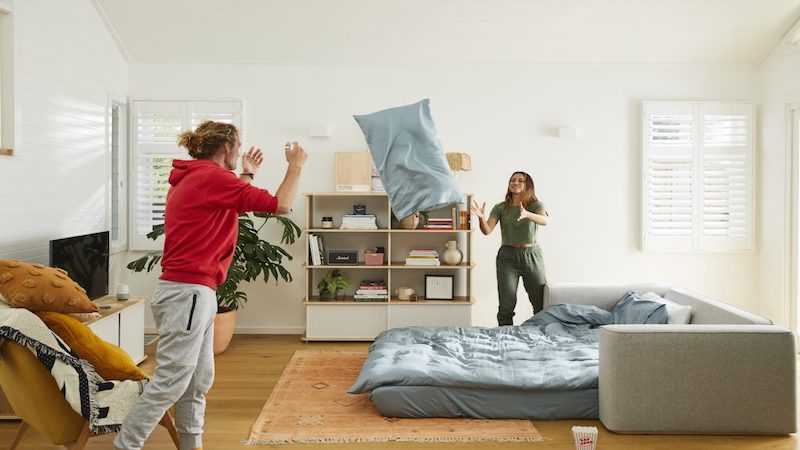 A woman and man setting up a sofa bed