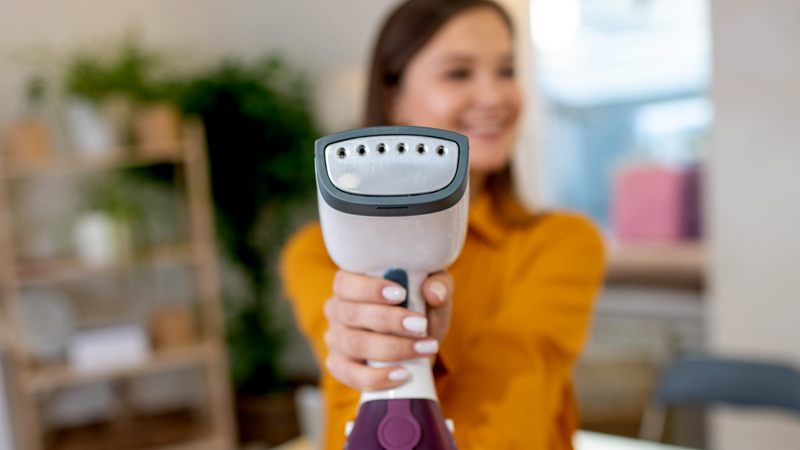 Woman using a clothes steamer