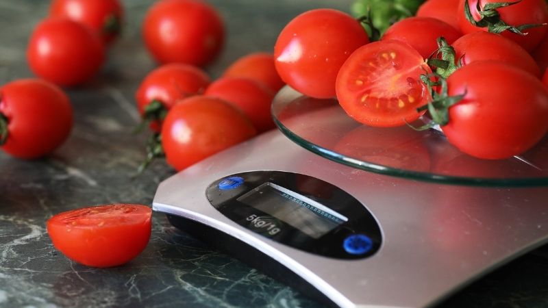 Weighing tomatoes on kitchen scales