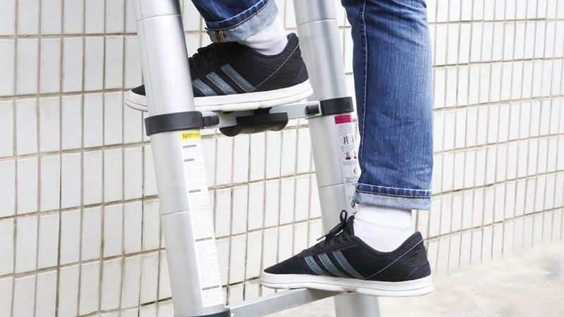 Man climbing telescopic ladder